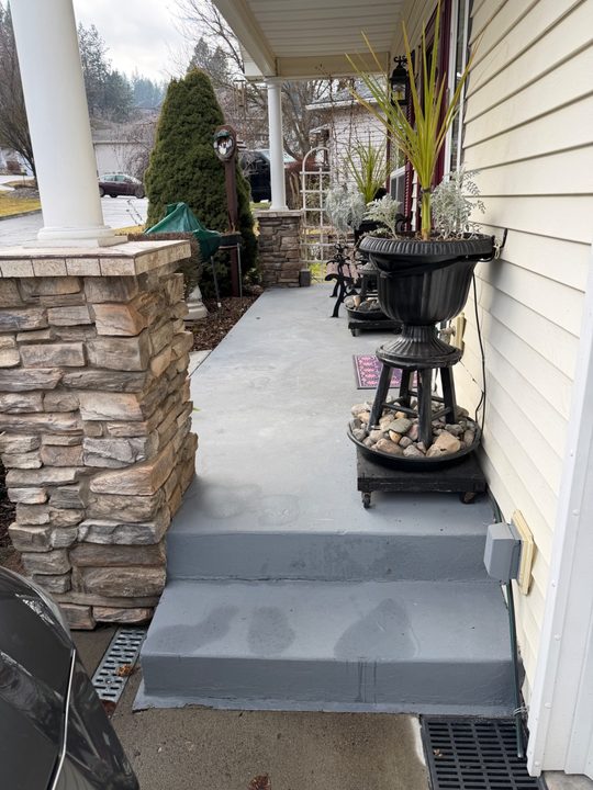 Before: black handrail beside a two-step porch entry next to a stone column