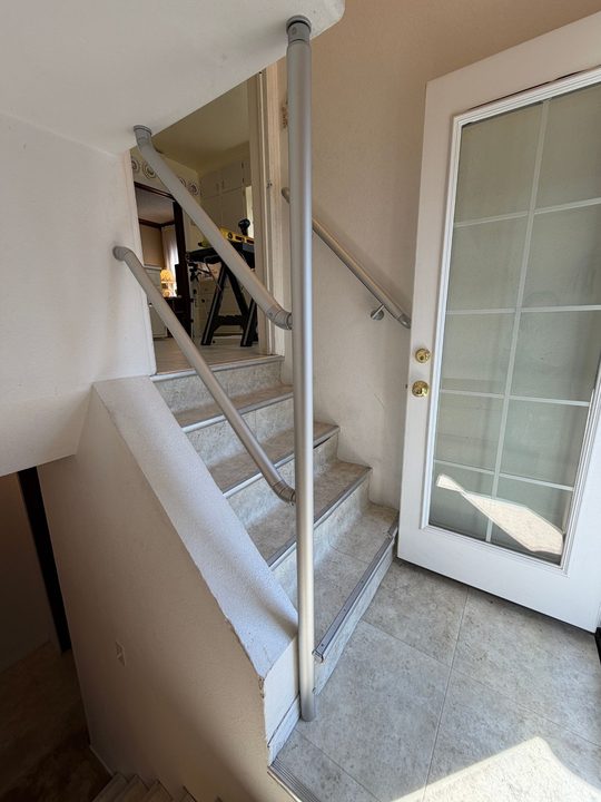 After: stairway with handrails on both sides and a floor to ceiling support post