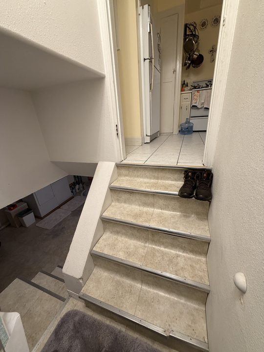Before: stairway with handrails on both sides and a floor to ceiling support post